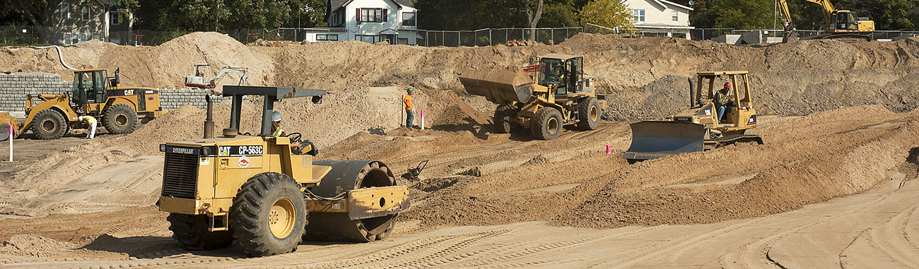 Bulldozers grade the earth at a construction site