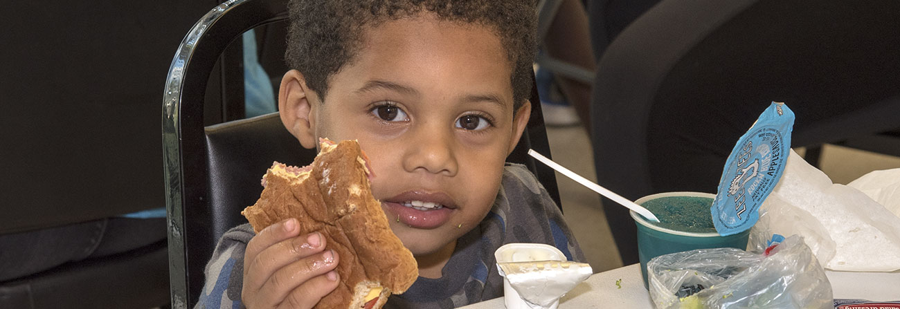 little boy eating a sandwich